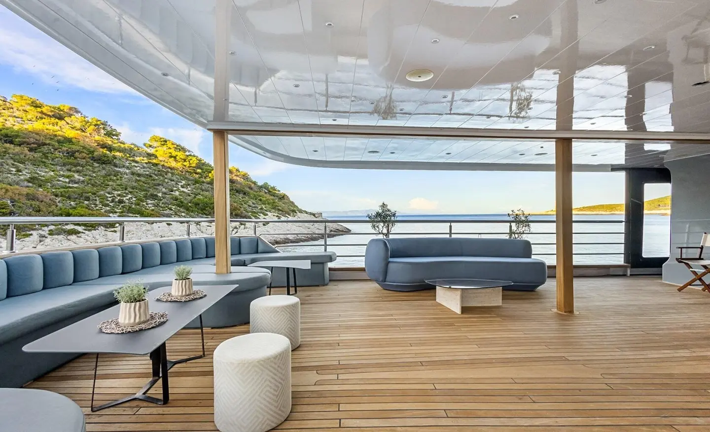 Bella yacht deck view with seating, white cushions, and railing overlooking water