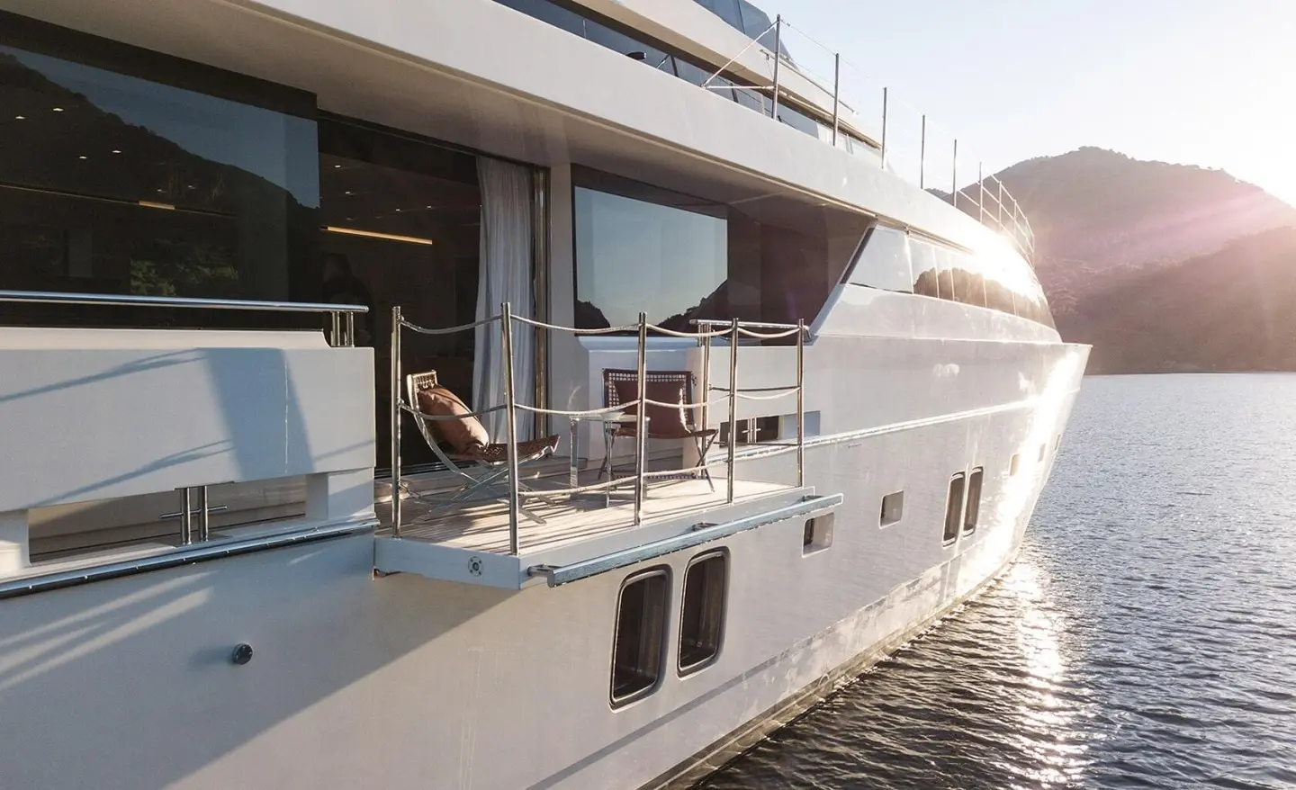 Morning Star yacht deck side view with glass doors and railing at sunset
