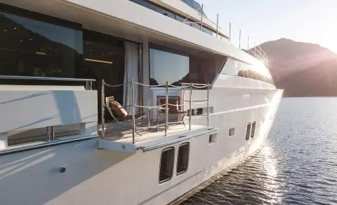 Morning Star yacht deck side view with glass doors and railing at sunset