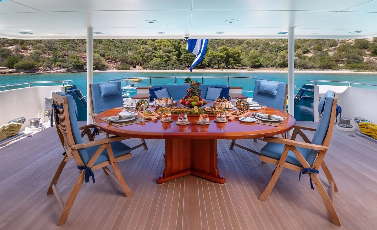 Magix yacht main deck aft dining table with people onboard under blue sky