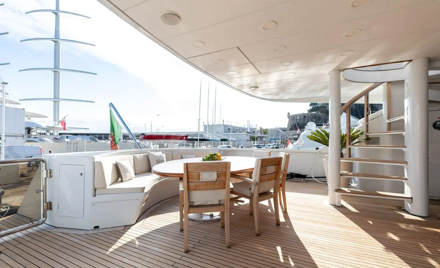 Yacht Brooklyn aft deck with wooden table and chairs, sheltered by overhead cover