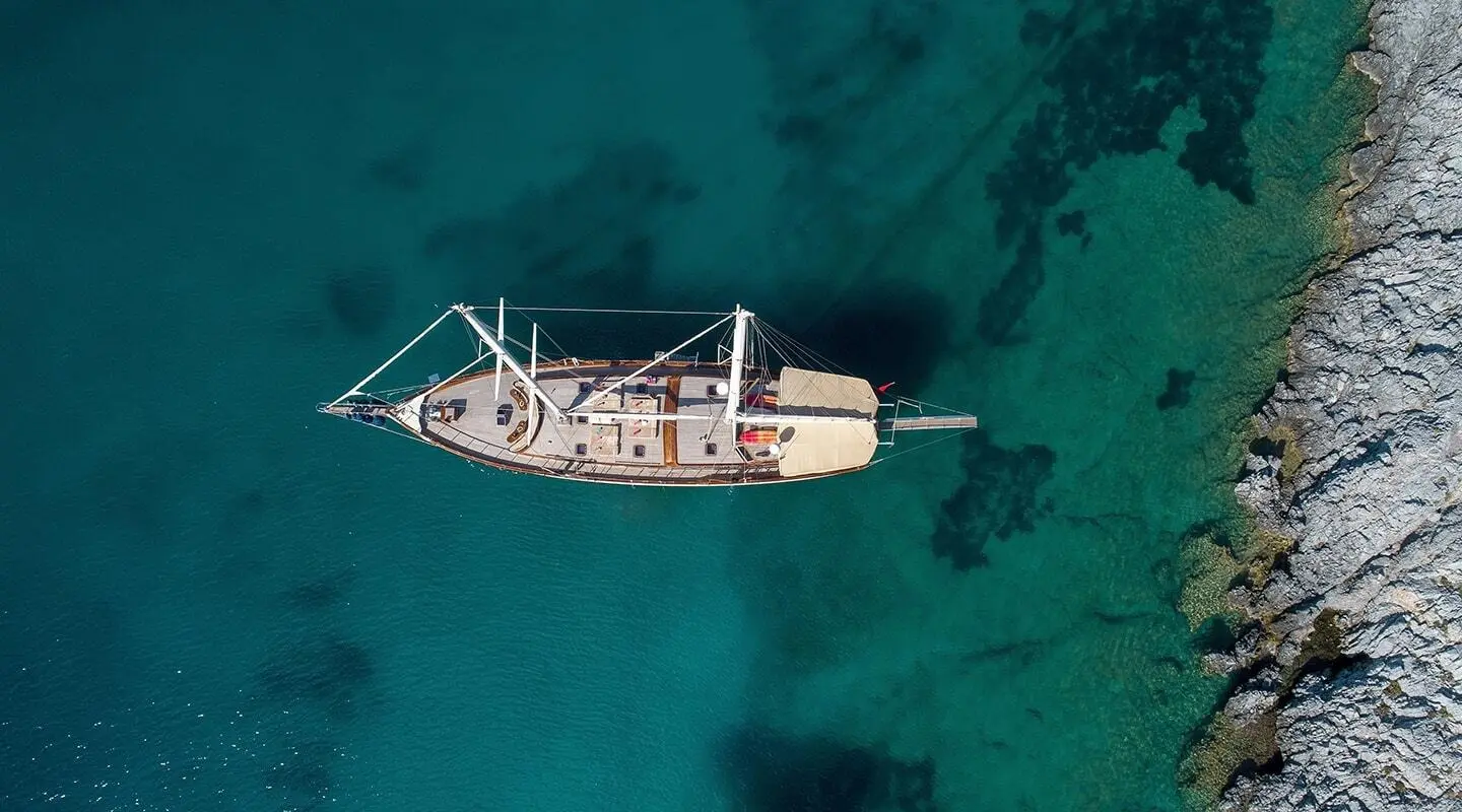 Zephyria II yacht anchored in turquoise water with shadowed hull