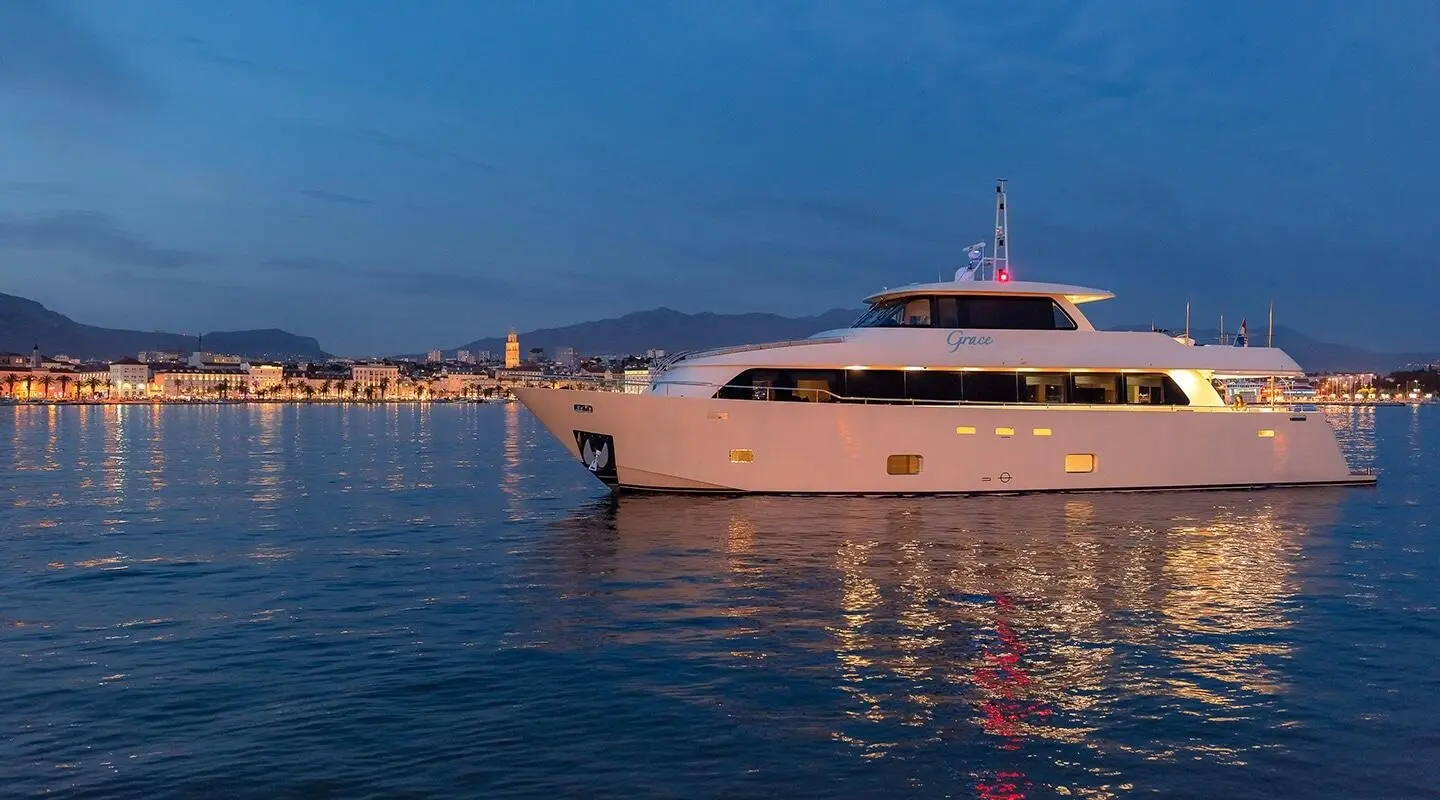 Grace yacht anchored at sunset, calm water reflections visible