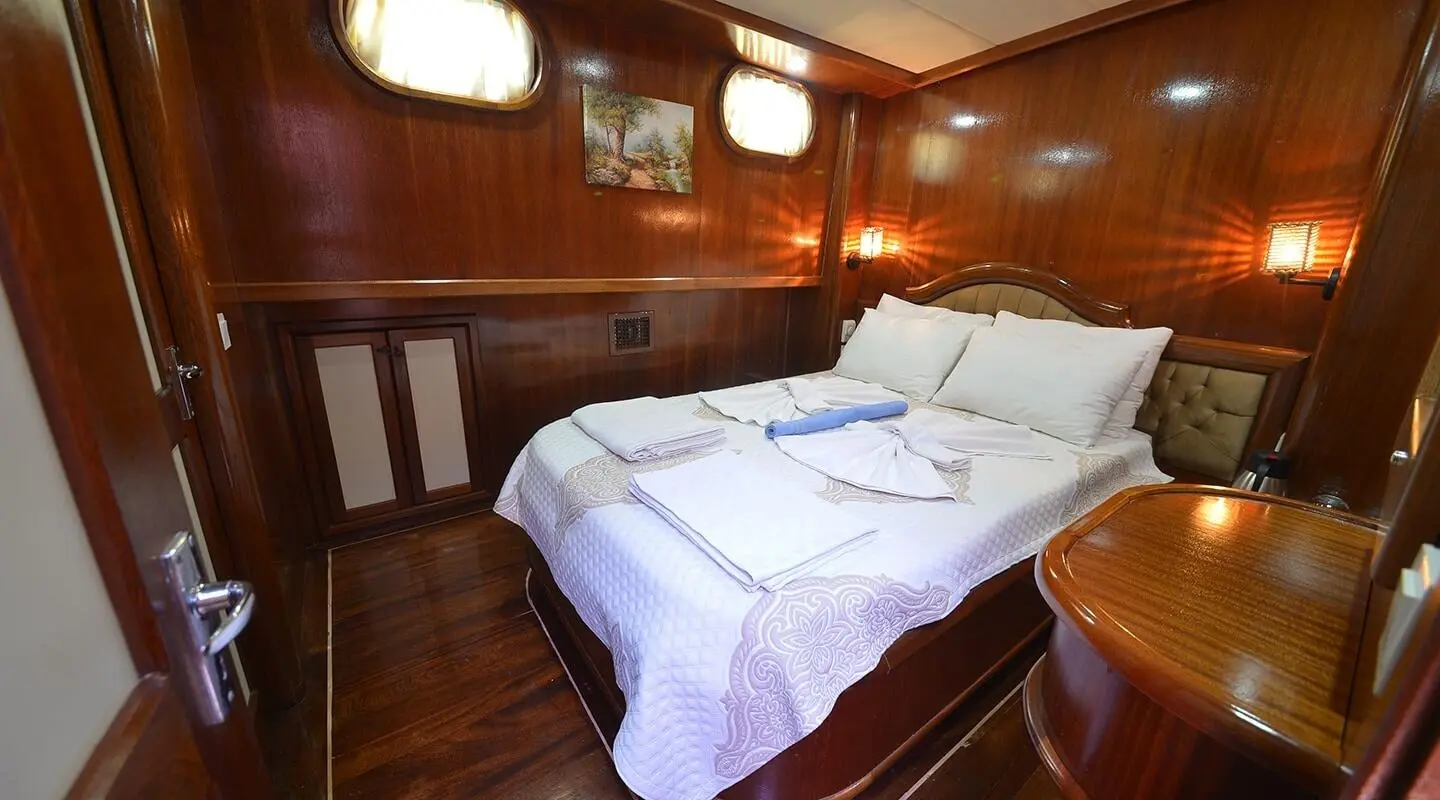 Interior view of a yacht cabin with two single beds and wooden paneling