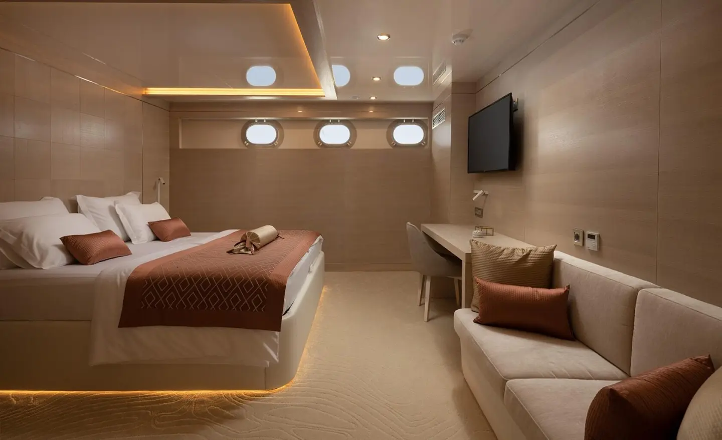 Love Story yacht interior with bed, seating area, warm lighting, and TV
