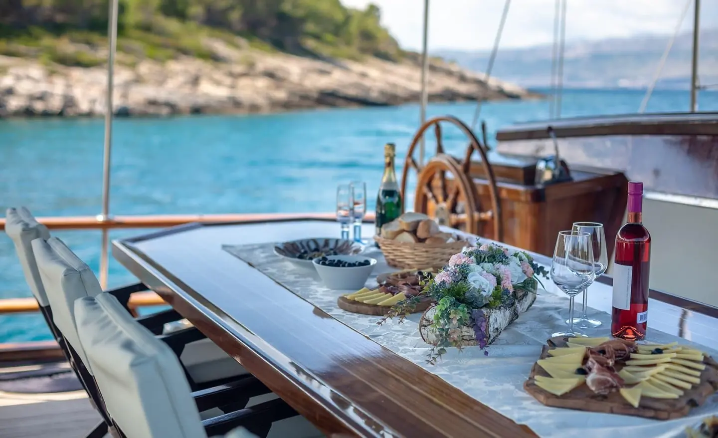 Andi Star gulet aft deck with wooden helm, seating, and view of sea