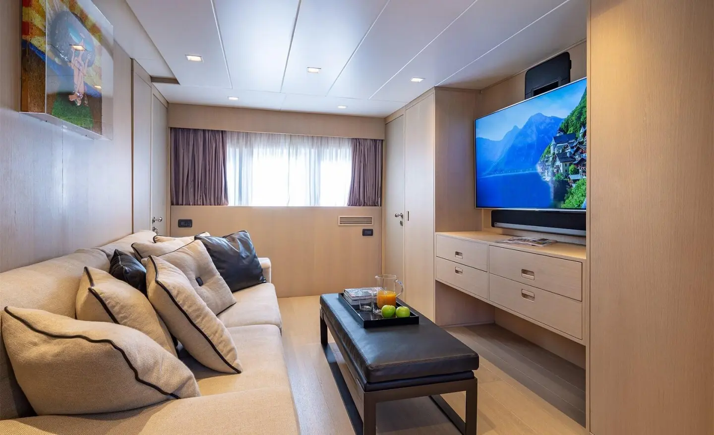 Interior of the yacht with a fabric sofa and a TV on a cabinet