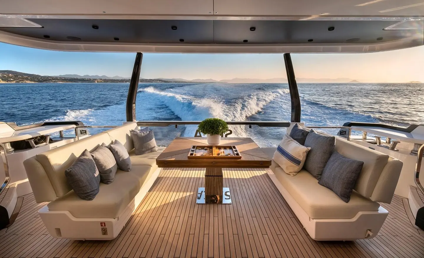 Spica yacht deck seating area with sun loungers and table, ocean view