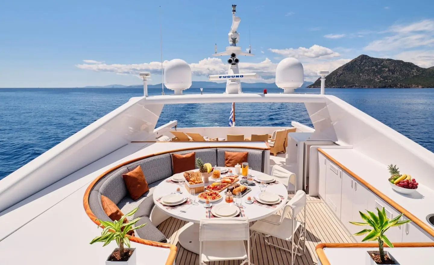 Mobius yacht deck dining area with a table set for meals amid blue sea