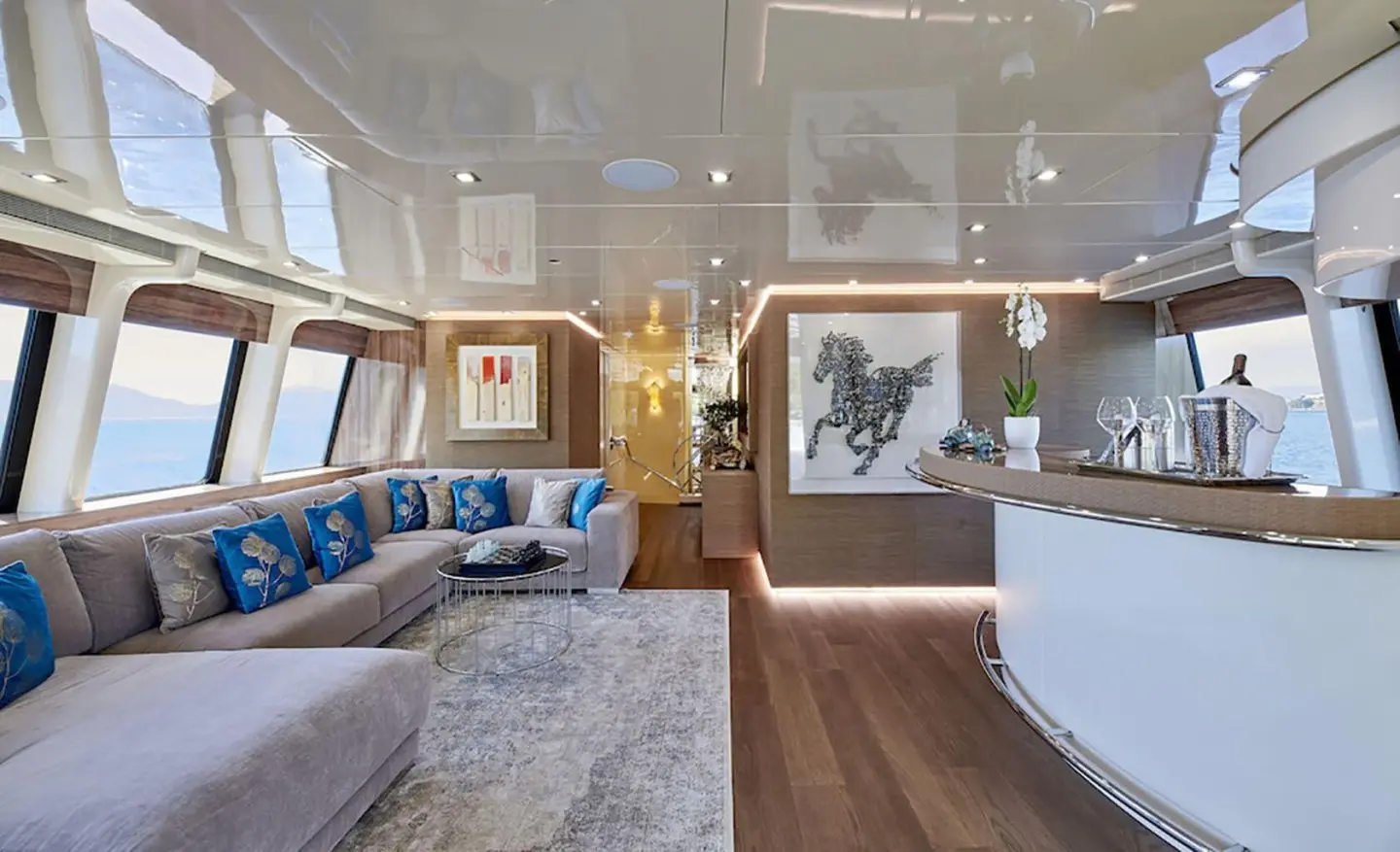 Daloli yacht saloon deck: bright seating area with blue cushions and large windows