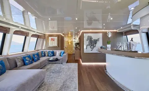 Daloli yacht saloon deck: bright seating area with blue cushions and large windows