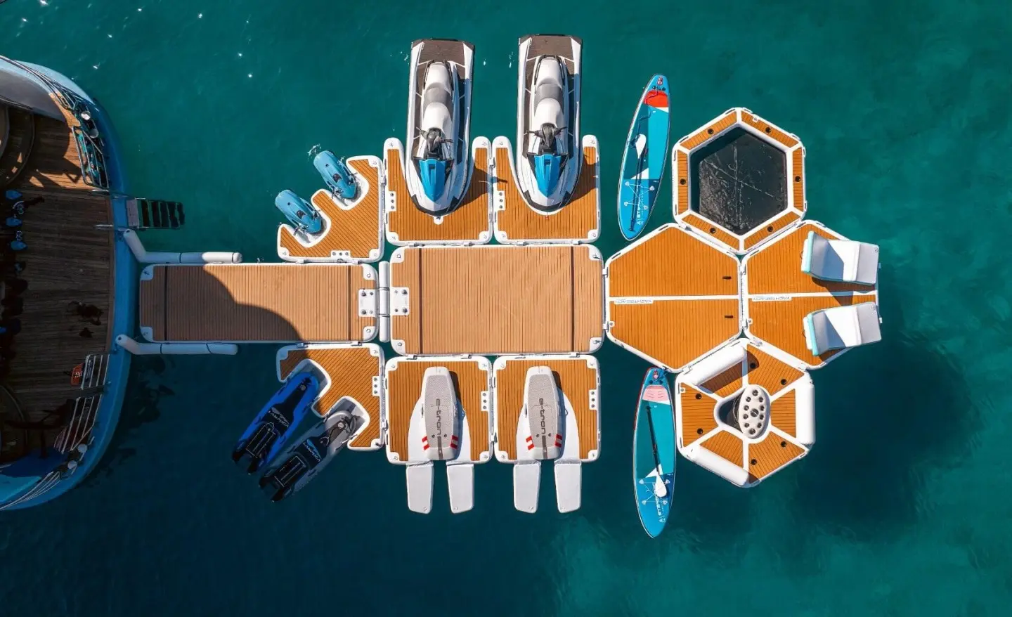 Top-down view of a yacht named Freedom docked with water toys nearby
