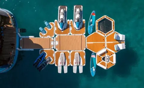 Top-down view of a yacht named Freedom docked with water toys nearby
