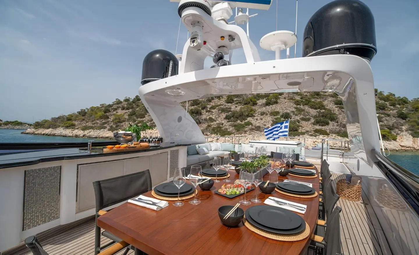 Pareaki II dining deck with table settings and sun loungers on yacht
