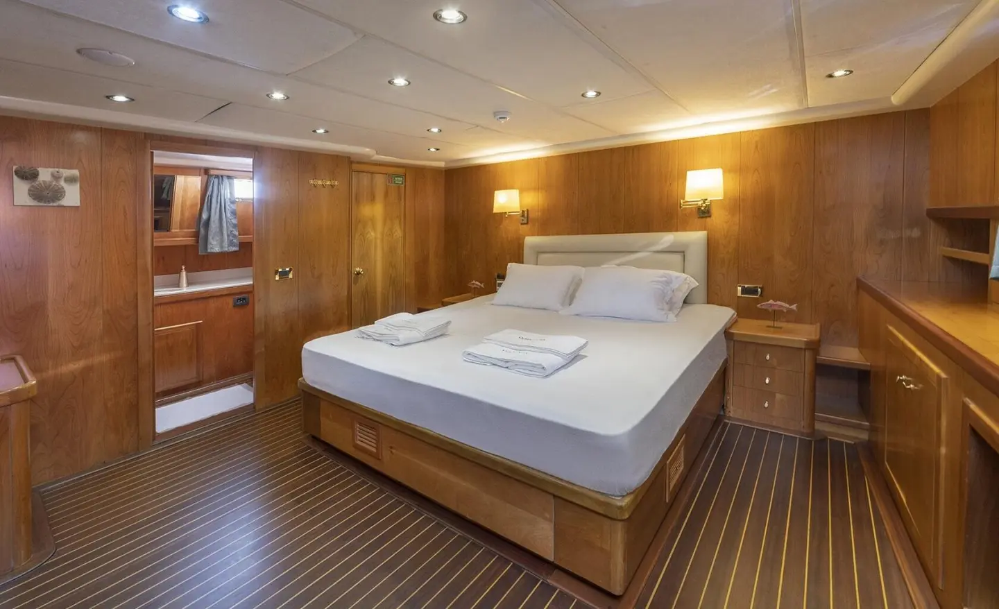 Queen Of Sea luxury gulet sailing sunset interior cabin with wooden walls and bed