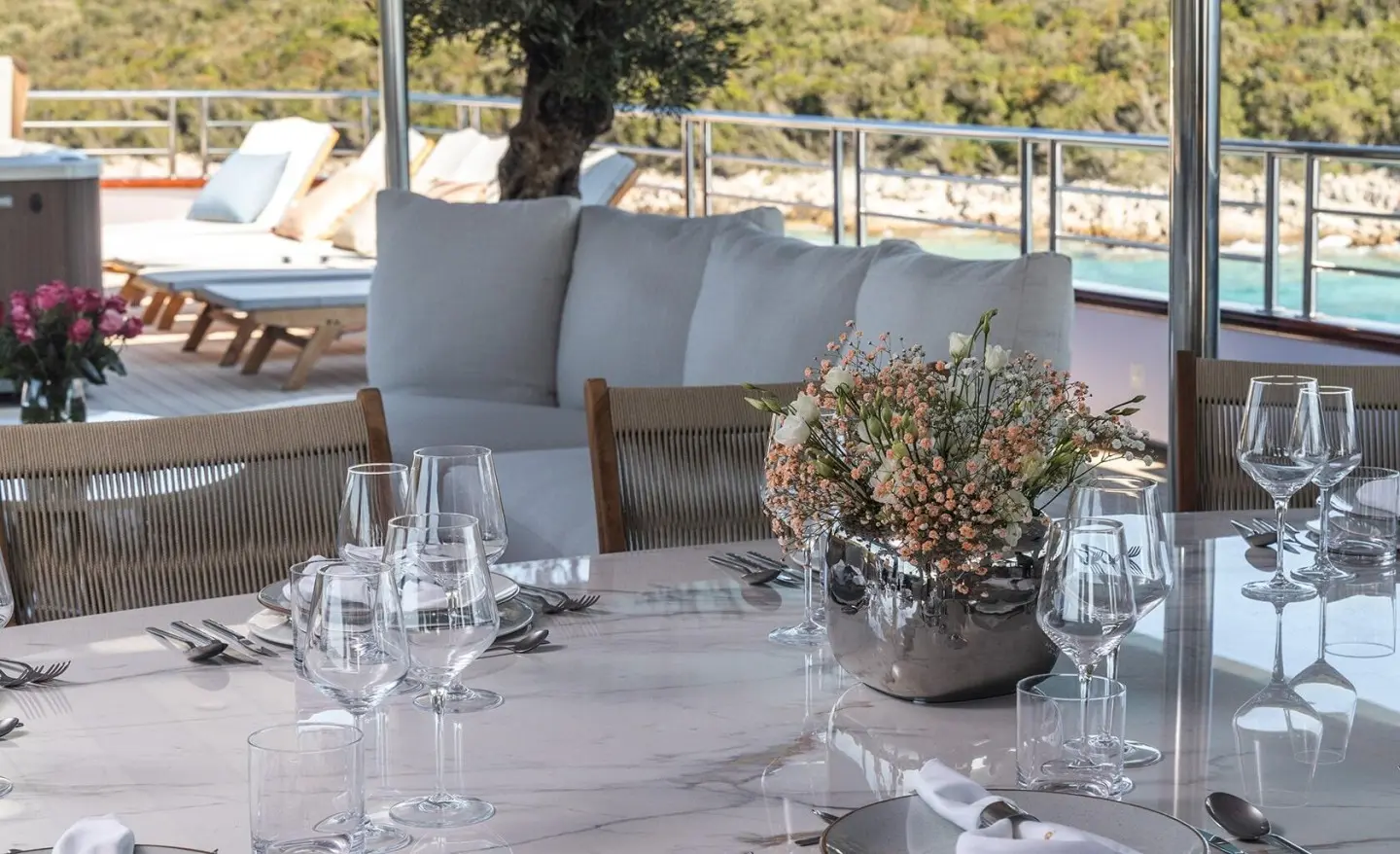 Table setting with a floral centerpiece and glassware on a dining table aboard a yacht