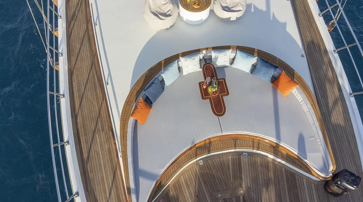 View of a sunset-lit luxury gulet yacht Diva Deniz, wooden deck and blue hull