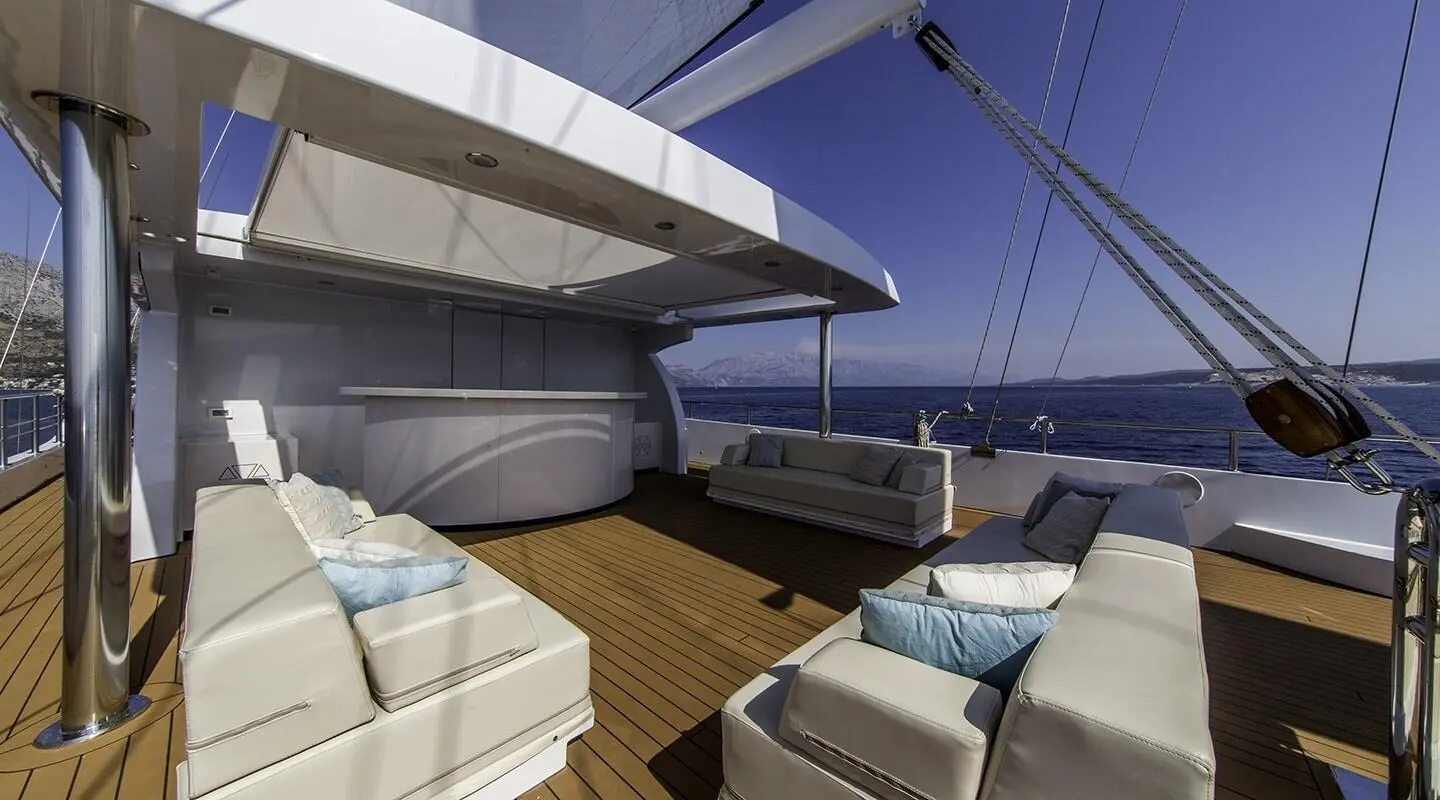 Omnia yacht lounge area with sunbeds on teak deck and ocean view
