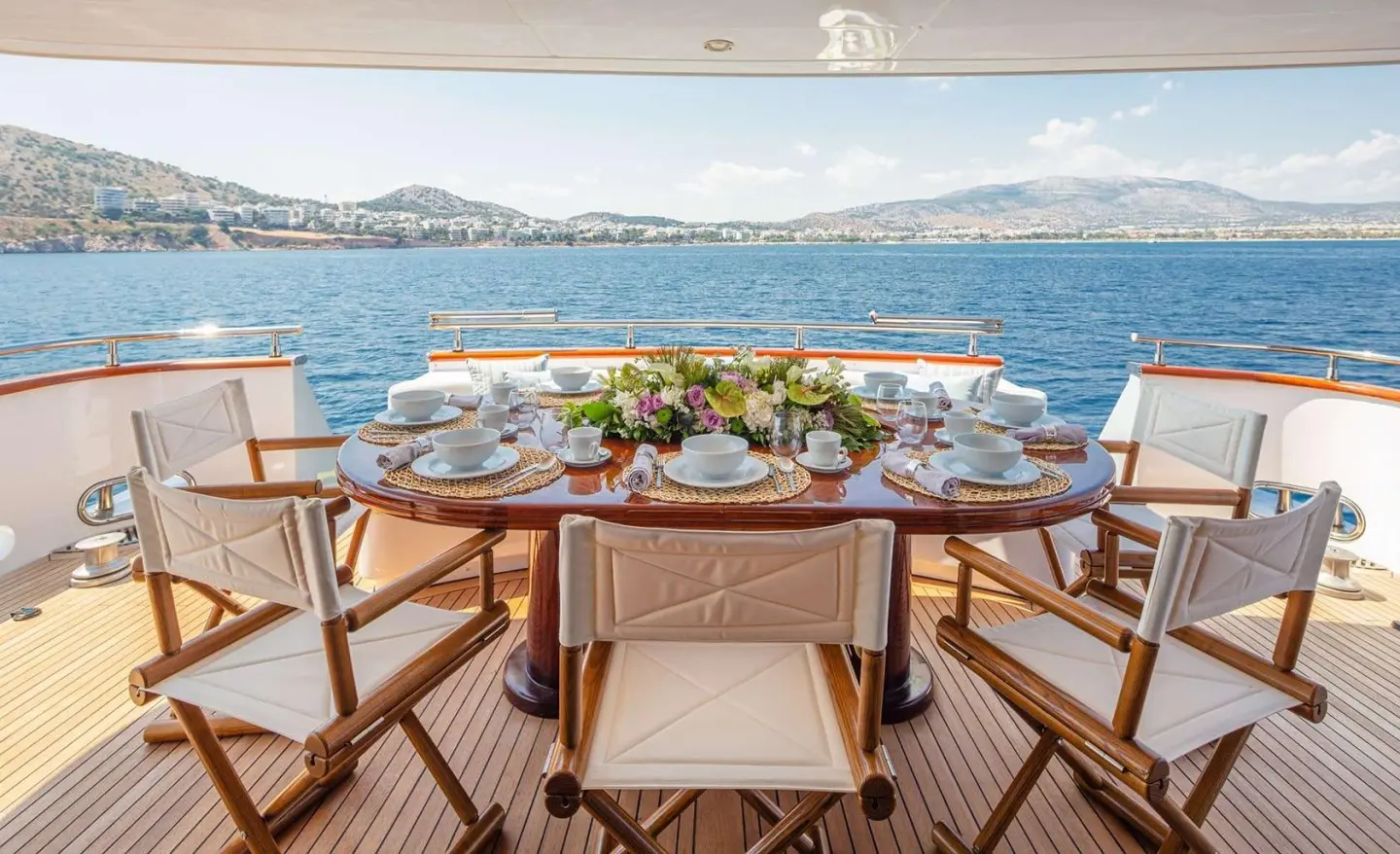 Grace yacht dining setup on deck at sunset with table settings and chairs