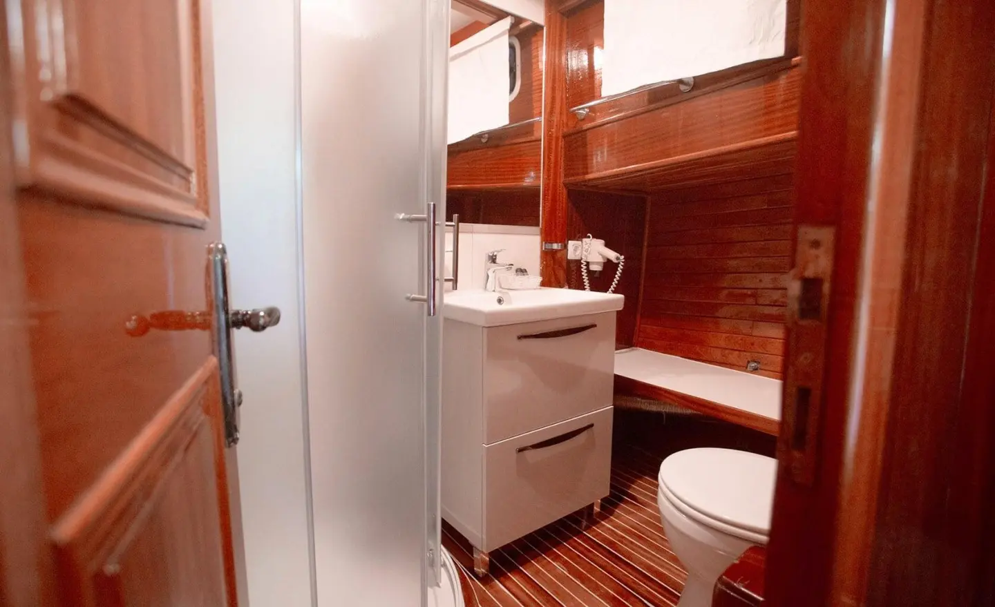 Luxurious yacht Malena interior with wooden cabinetry and white fixtures at sunset