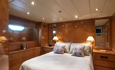 Luxurious yacht Idylle interior with wooden panels, bed, and pillows