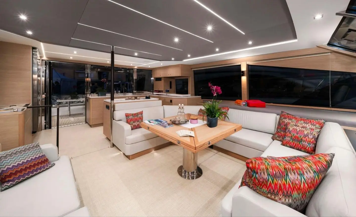 Luxurious yacht saloon aboard By My Side with seating, tables, and warm lighting