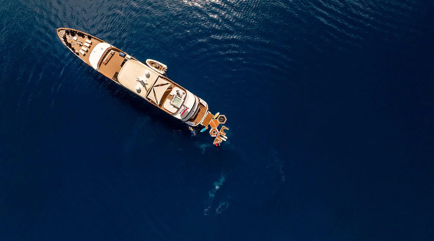 Yacht Cristal anchored in calm blue sea, viewed from above