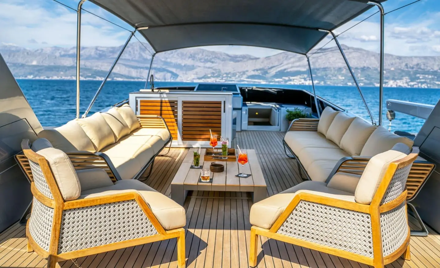 Phantom yacht deck seating area with beige cushions under a blue canopy