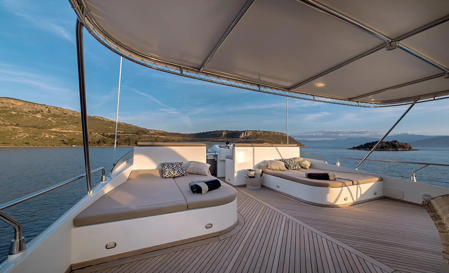 Aquila yacht deck with sun loungers and shaded seating on a harbor