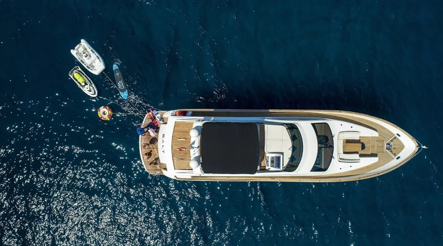 Top-down view of a white luxury motor yacht named Salt docked in deep blue water