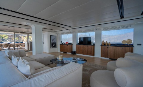 De Love luxury interior: spacious white lounge with sofa, round glass coffee table, TV cabinets, and panoramic windows