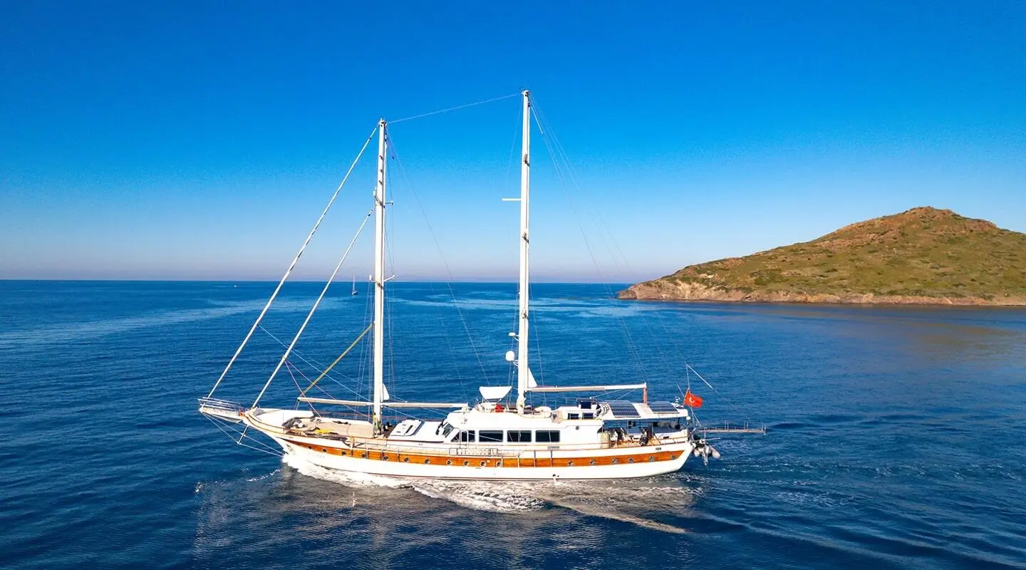 Sailing yacht with two masts cruising on blue sea, hull and deck visible