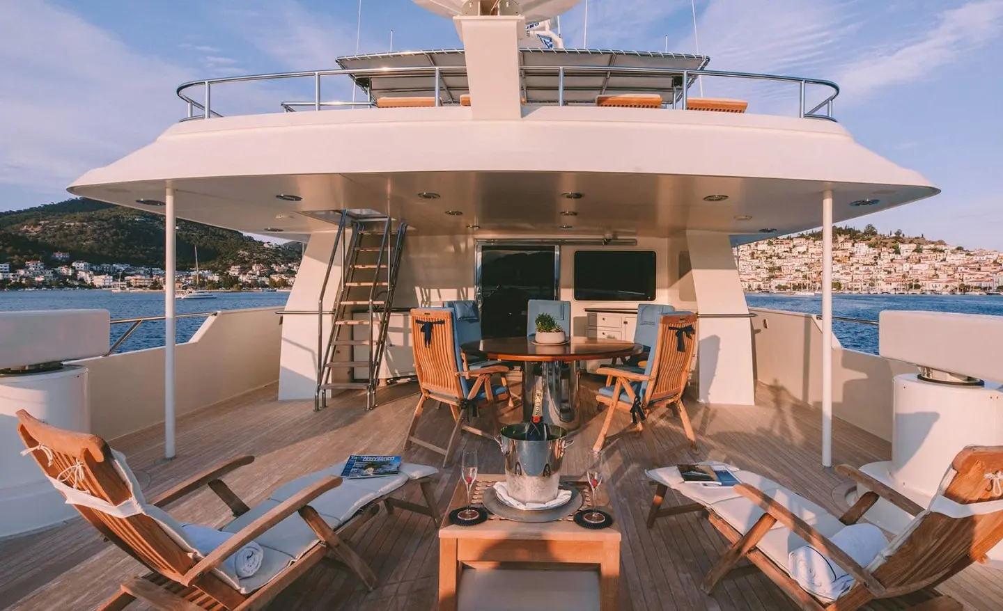 Luxury yacht Magix deck scene with seating, table, and ocean view