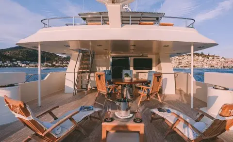 Luxury yacht Magix deck scene with seating, table, and ocean view
