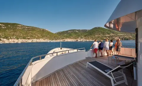 Lupus Mare yacht deck at sunset with calm blue sea and distant hills