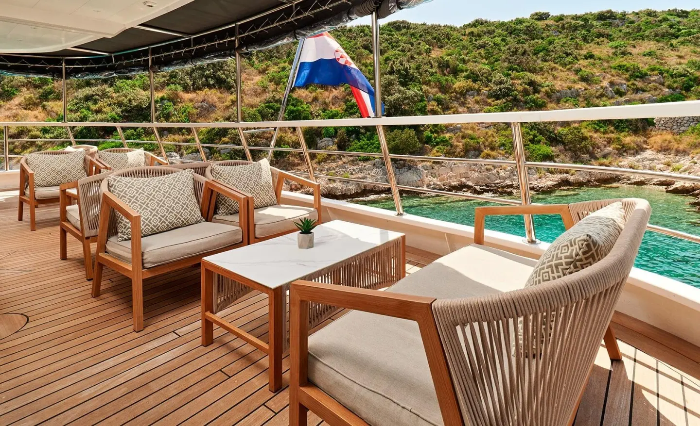 Lupus Mare yacht lounge on deck with chairs and a table at sunset