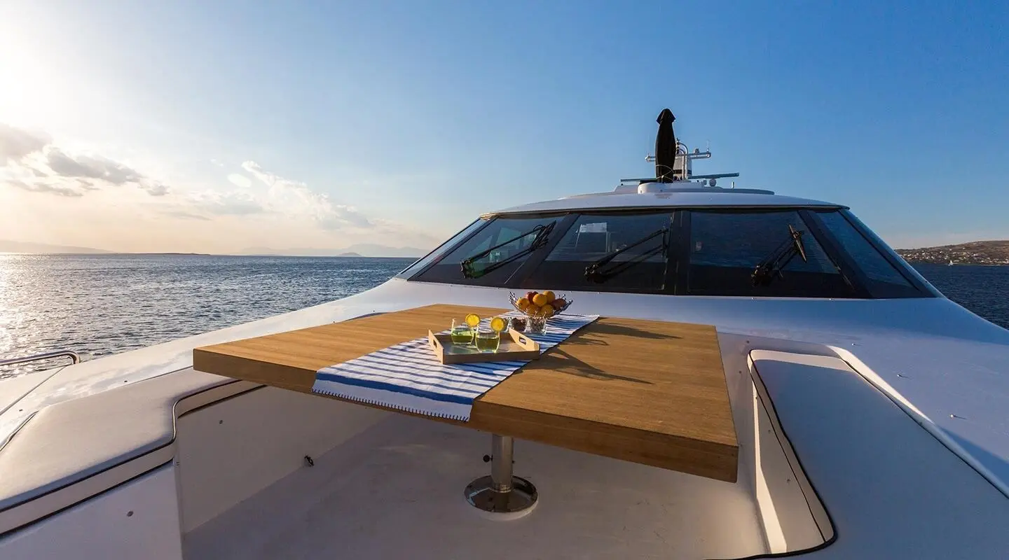 Bow deck of Aquarella yacht with wooden table and drinks on board