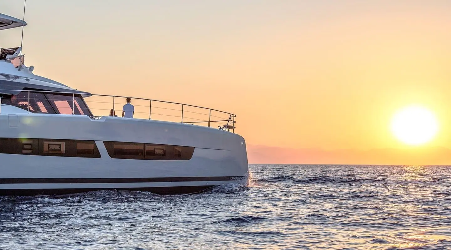 D2 yacht on calm sea at sunset, bow close to camera, warm sky