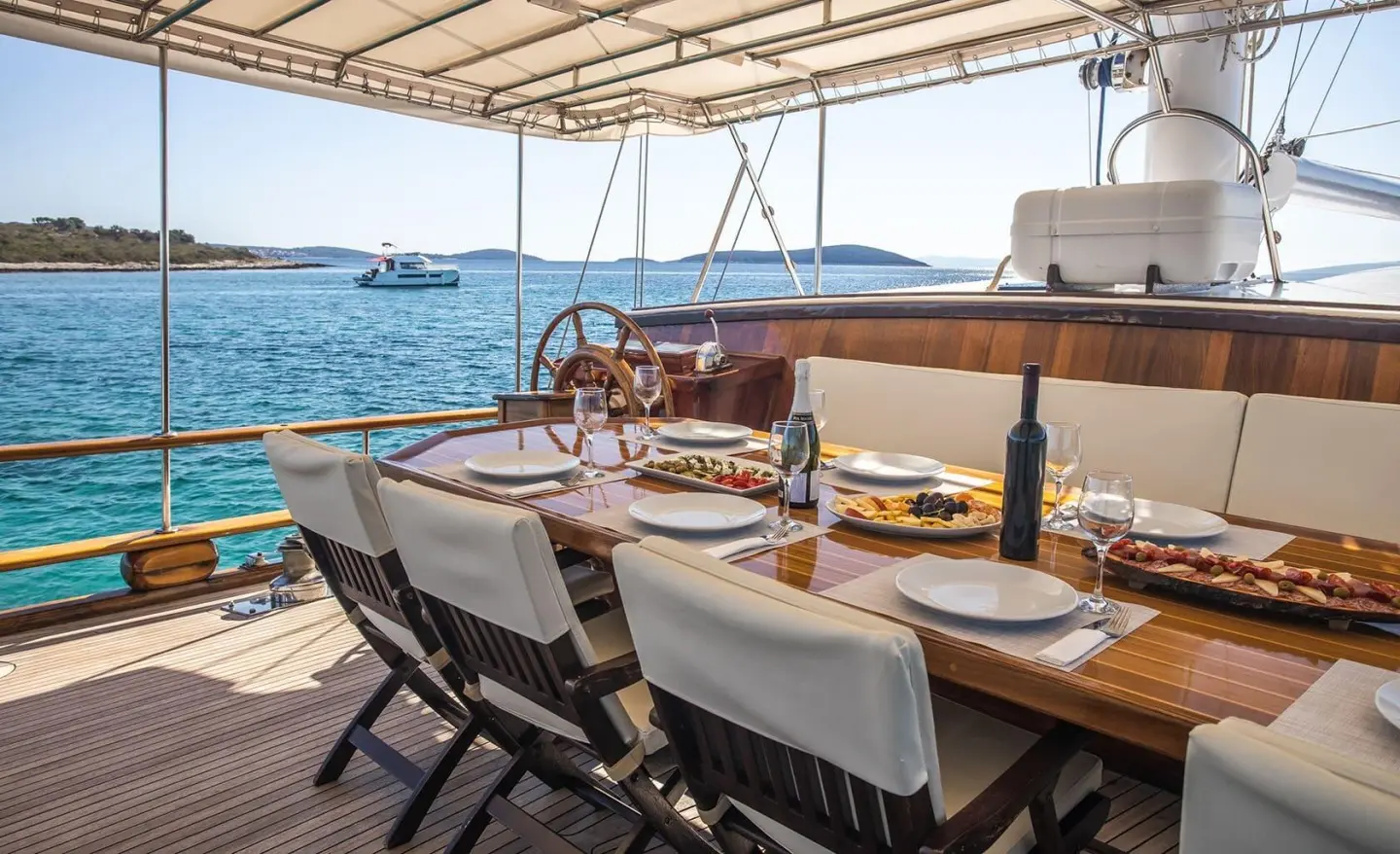 Dining table on Andi Star yacht with sea view sunset
