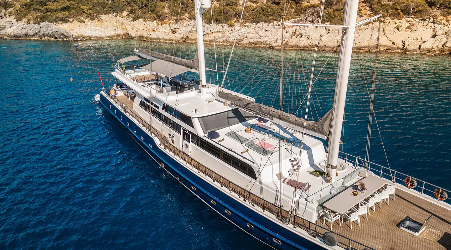 Esma Sultan yacht moored in clear blue water with sunbathing area and seating on the deck