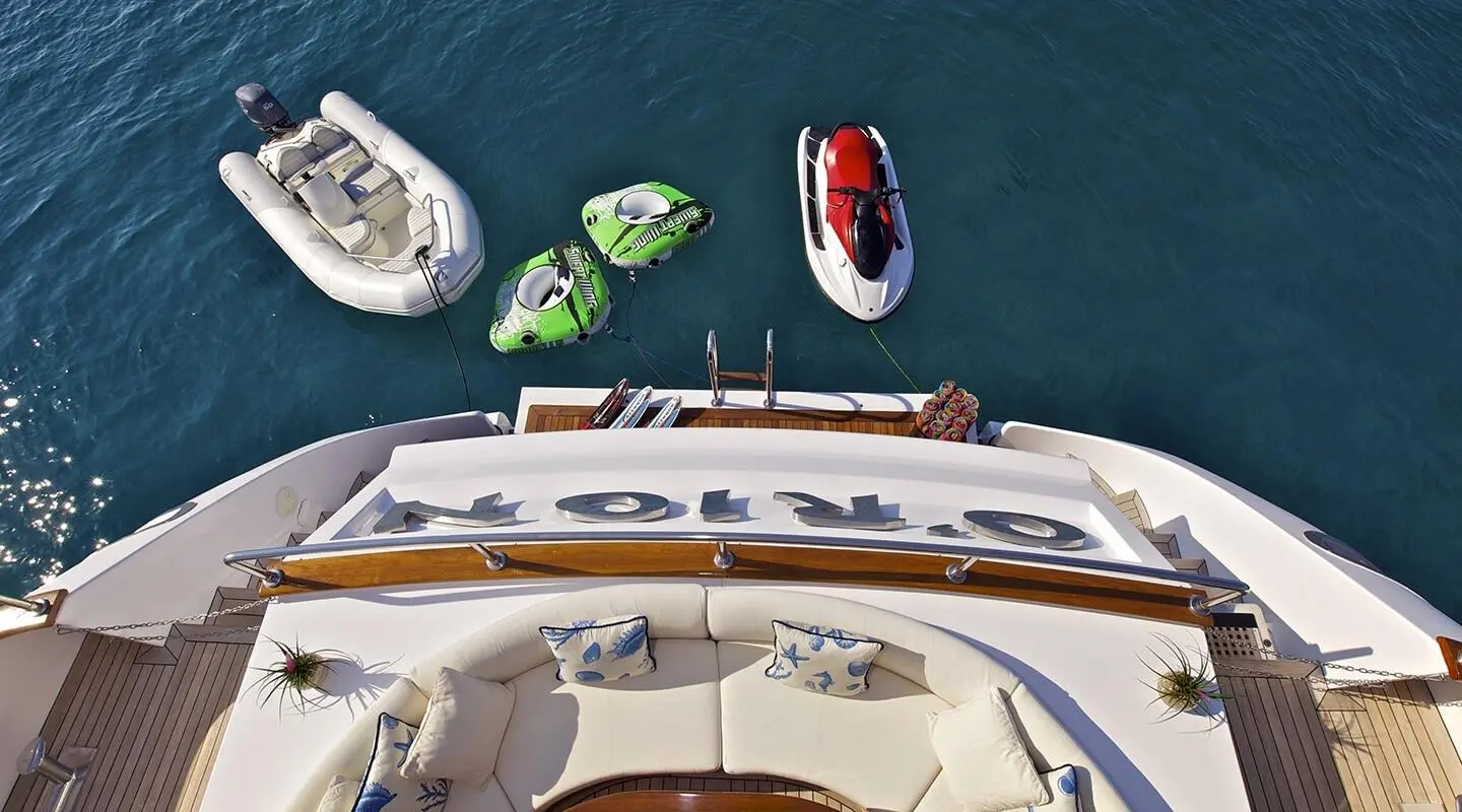 Top-down view of a luxury motor yacht docked in turquoise water