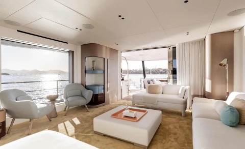 Viva II yacht saloon interior with white sofas and large windows, open door to outdoor deck and sea view