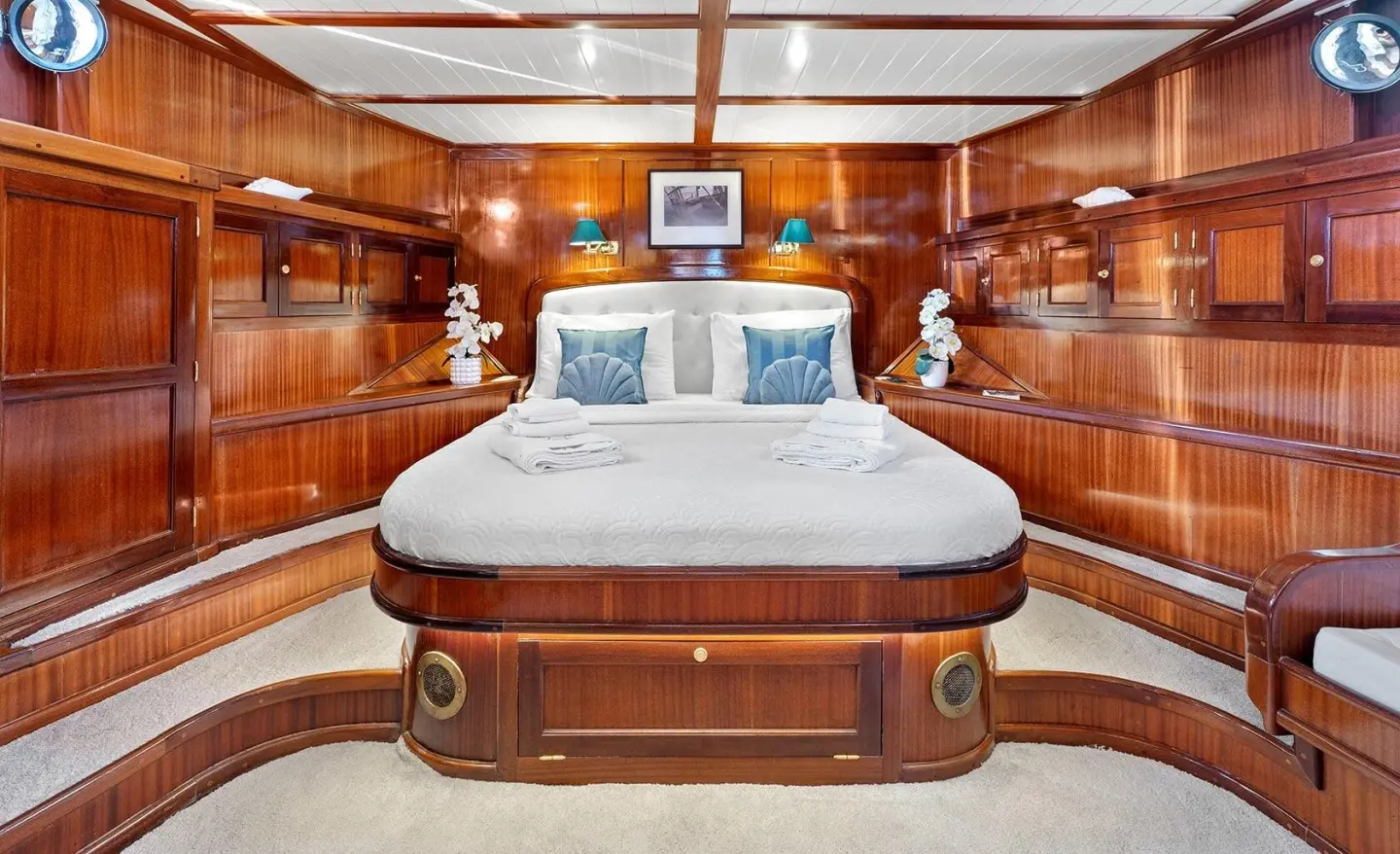 Luxurious yacht master cabin with polished wood paneling and a large bed
