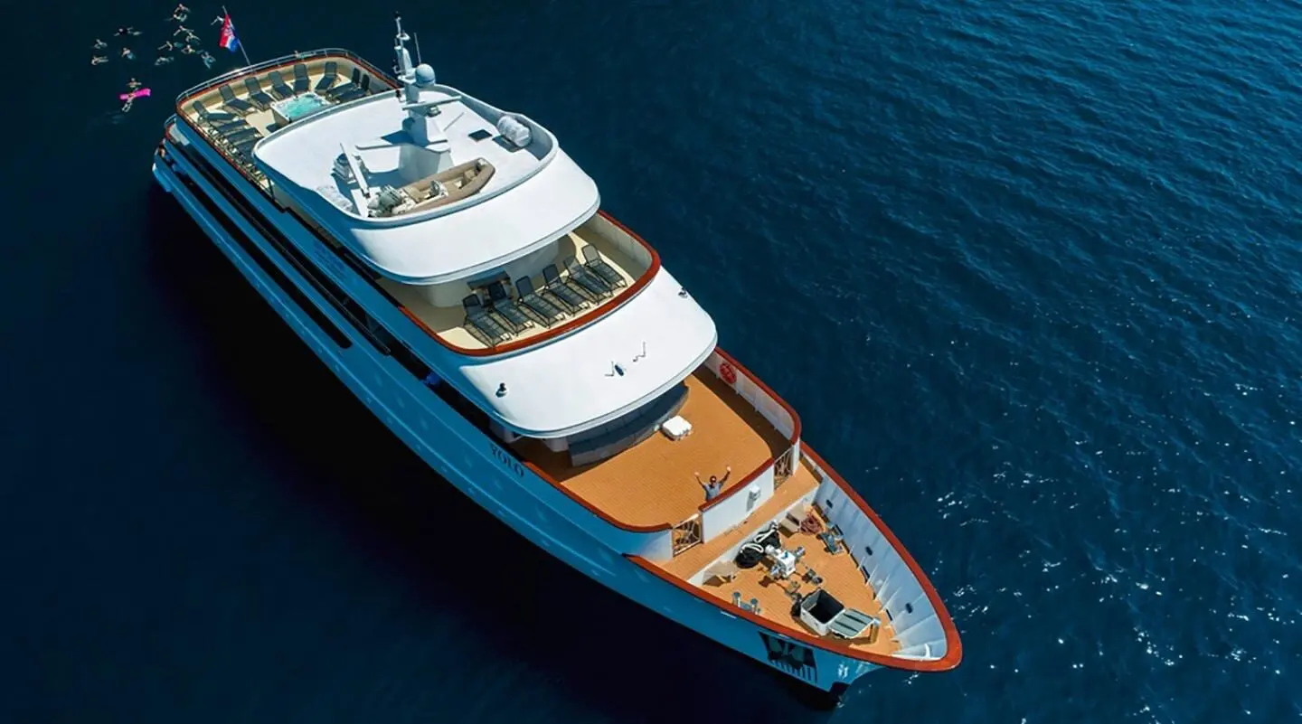 Top-down view of luxury yacht Yolo docked in calm blue water, deck visible