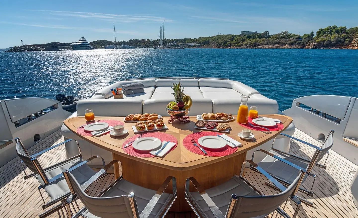 Table set for dining on a yacht bow with plates, glasses, and napkins