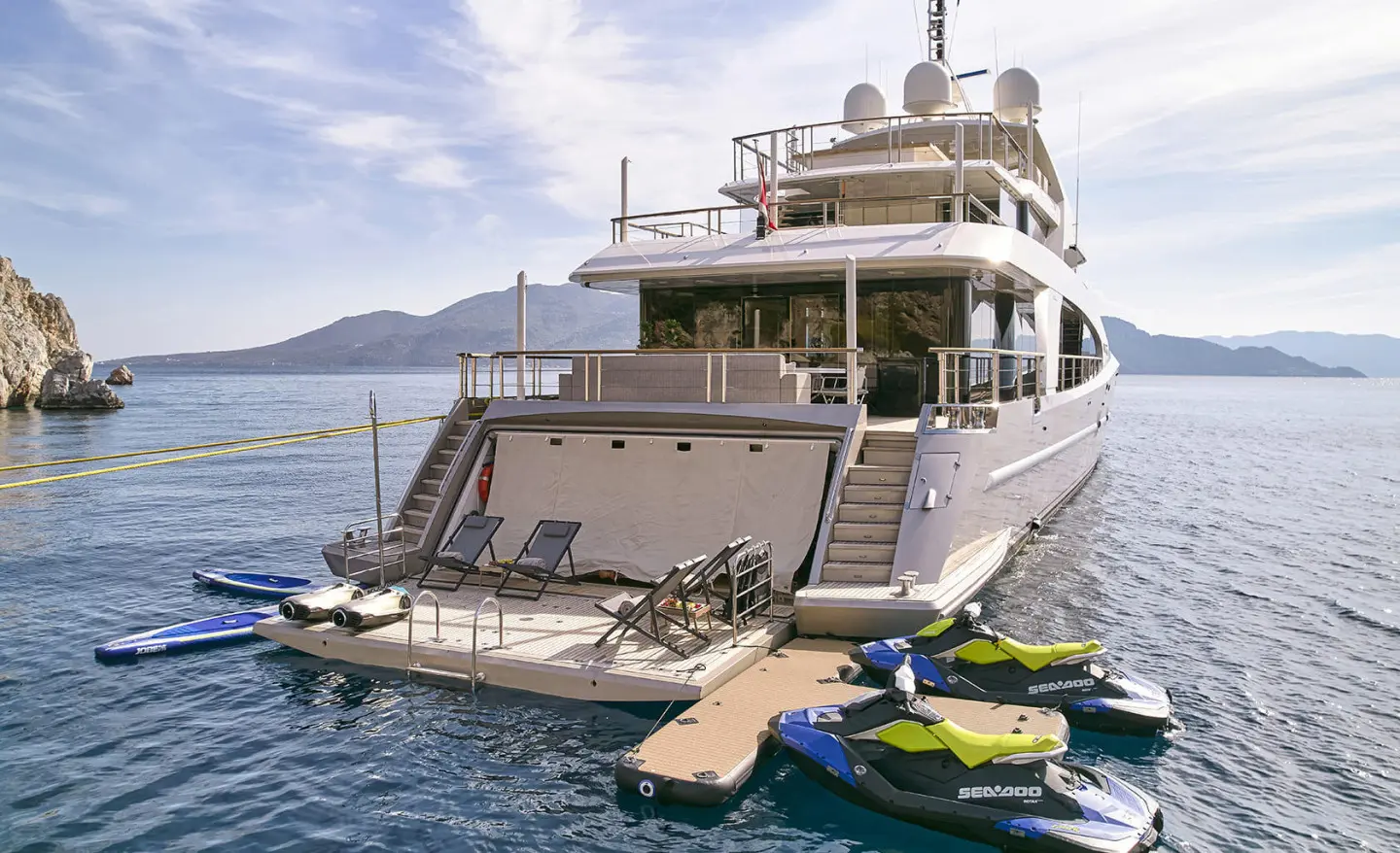 Yacht La Pellegrina 1 at sea with a small yellow and green dinghy alongside