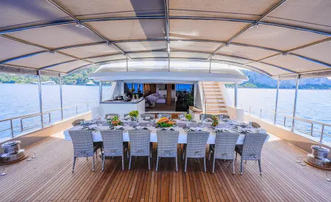 King of the Sea yacht dining area aboard at sunset, elegant table setup
