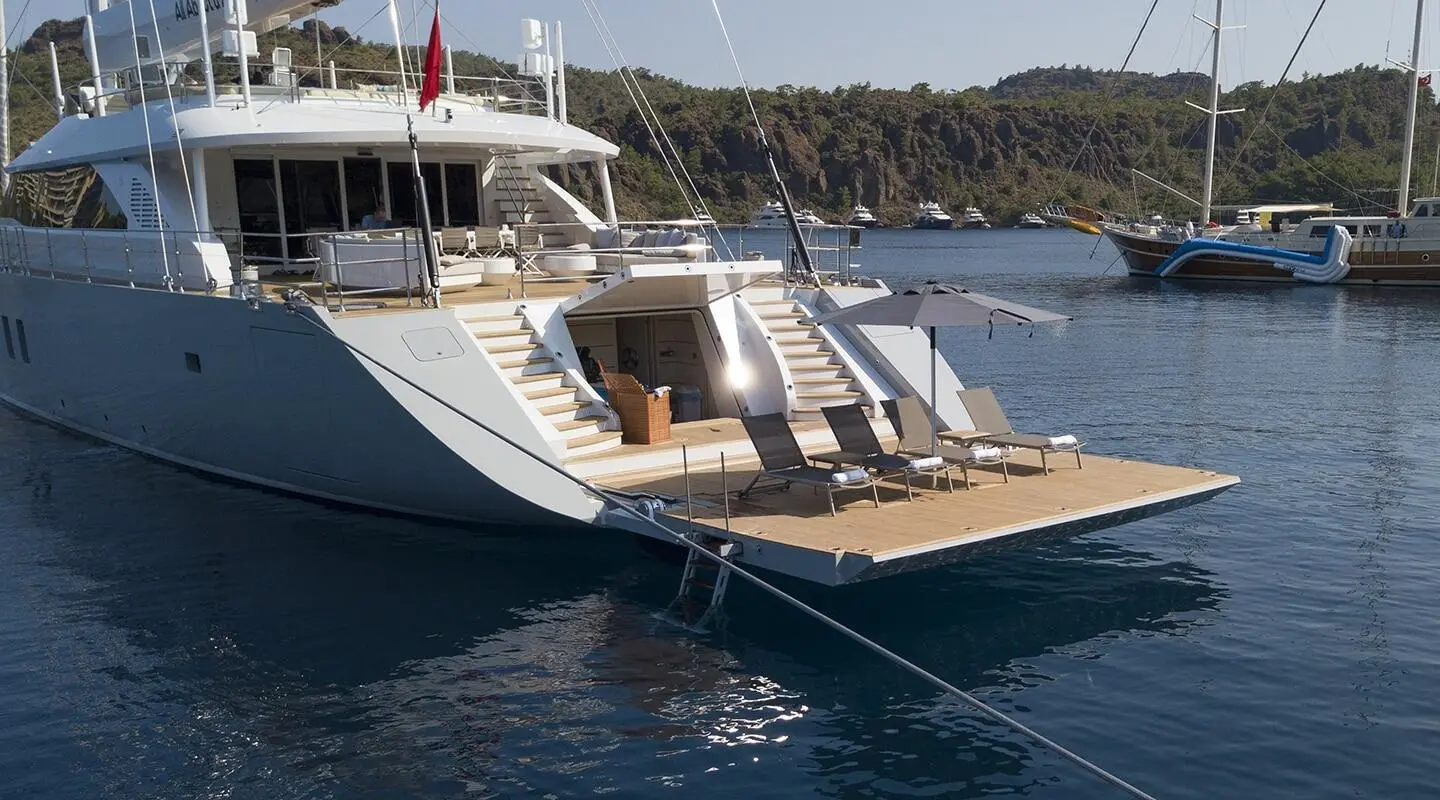 White and blue motor yacht with sun loungers on rear deck and open platform