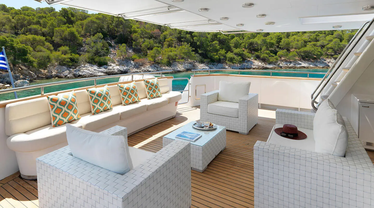 Idylle yacht deck seating area with white wicker sofas and a coffee table