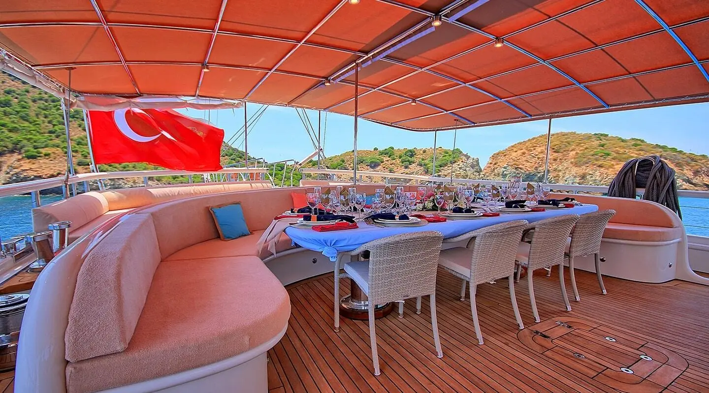 Queen Of Salmakis yacht, outdoor dining area under orange canopy overlooking harbor